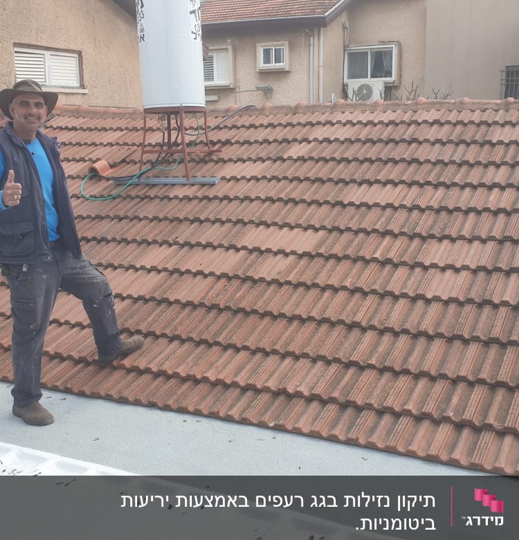 אדם עומד על גג רעפים עם דוד שמש